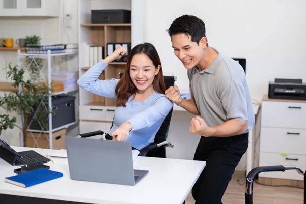 A man and a woman celebrating launching their new website after choosing the right hosting package A man and a woman celebrating launching their new website after choosing the right hosting package