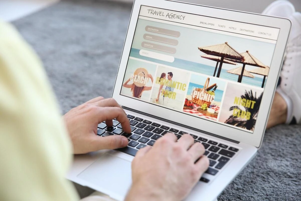 Person browsing a travel agency website on a laptop, illustrating how visitors navigate a small business website