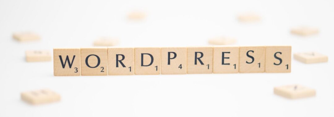 Scrabble tiles spelling out WORDPRESS arranged in a row on a white background