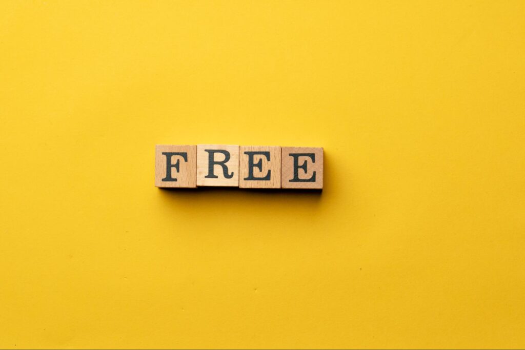 Wooden letter blocks spelling FREE on a bright yellow background